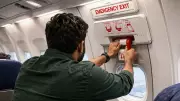 Passenger Attempts to Open Emergency Door Mid-Flight, Claims Possession