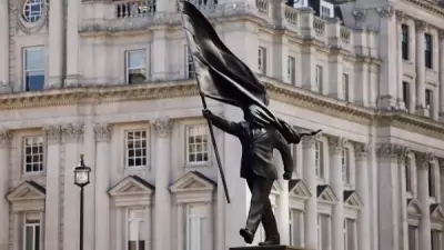 Banksy Unveils Statue of Flag-Wielding Man Poised to Step Off Plinth in London